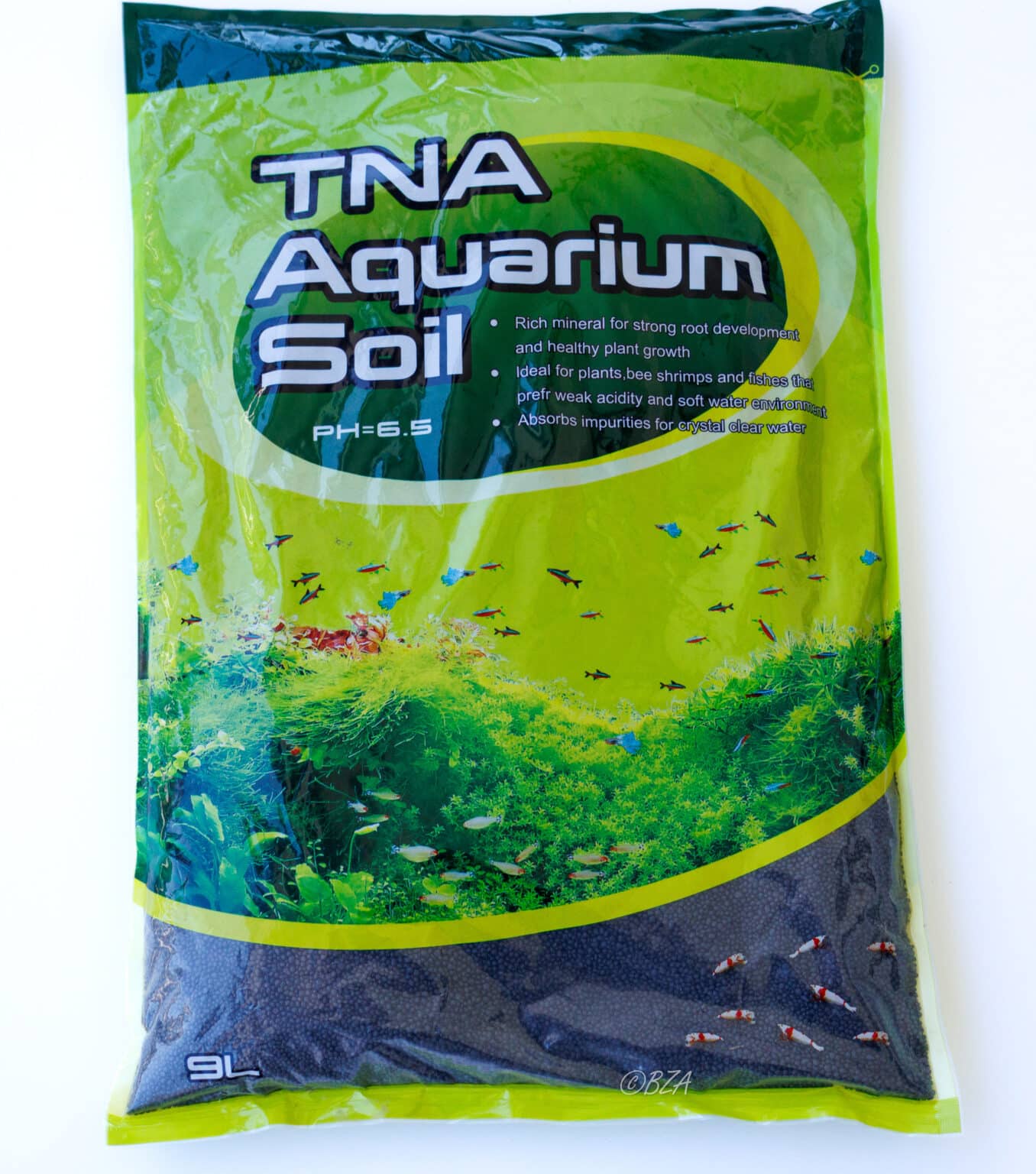 TNA Aquarium Soil 9L bag with green aquascape background and labeled pH 6.5 substrate for plants and shrimp.