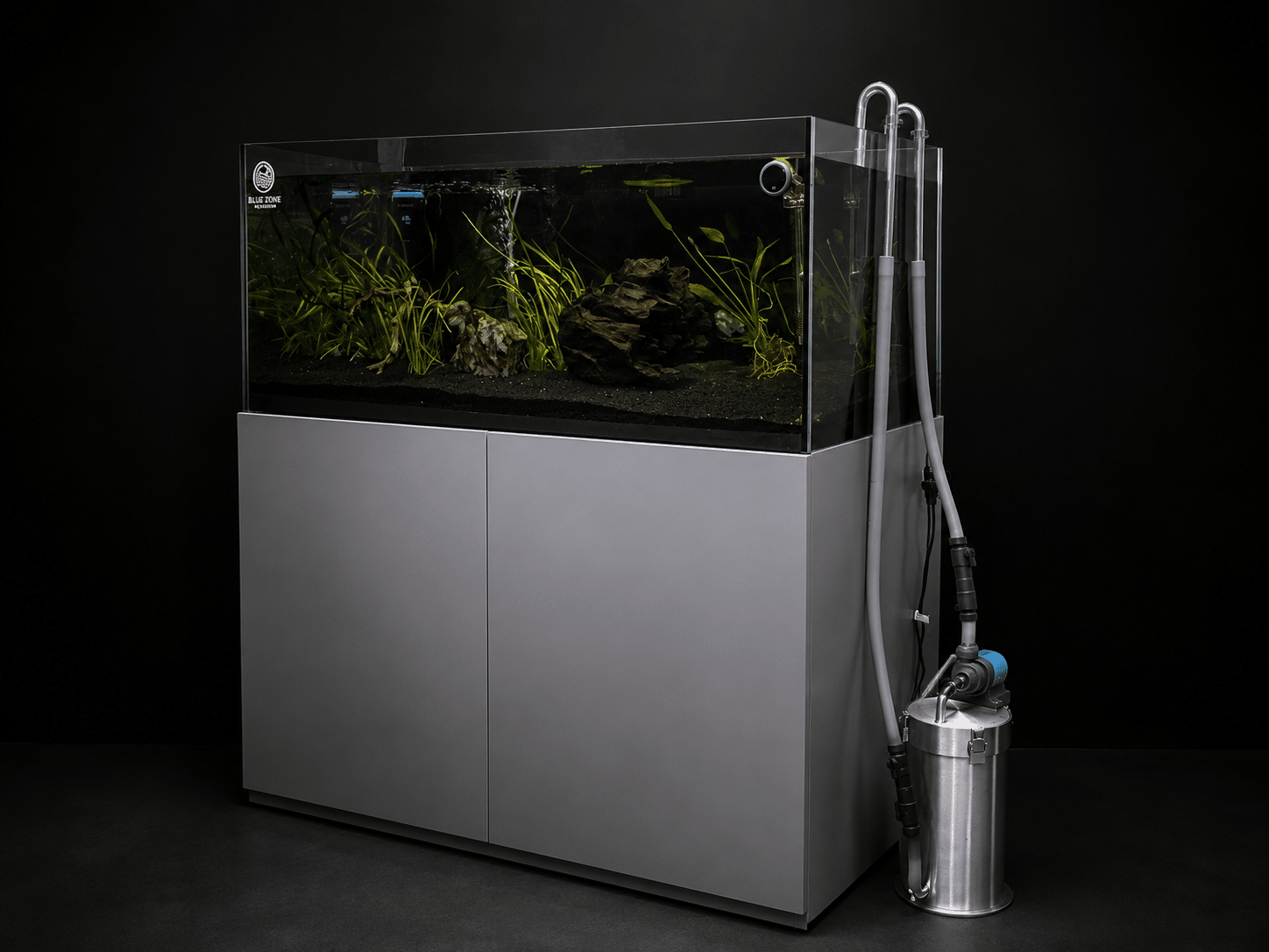 Modern planted aquarium with external canister filter on a black studio background